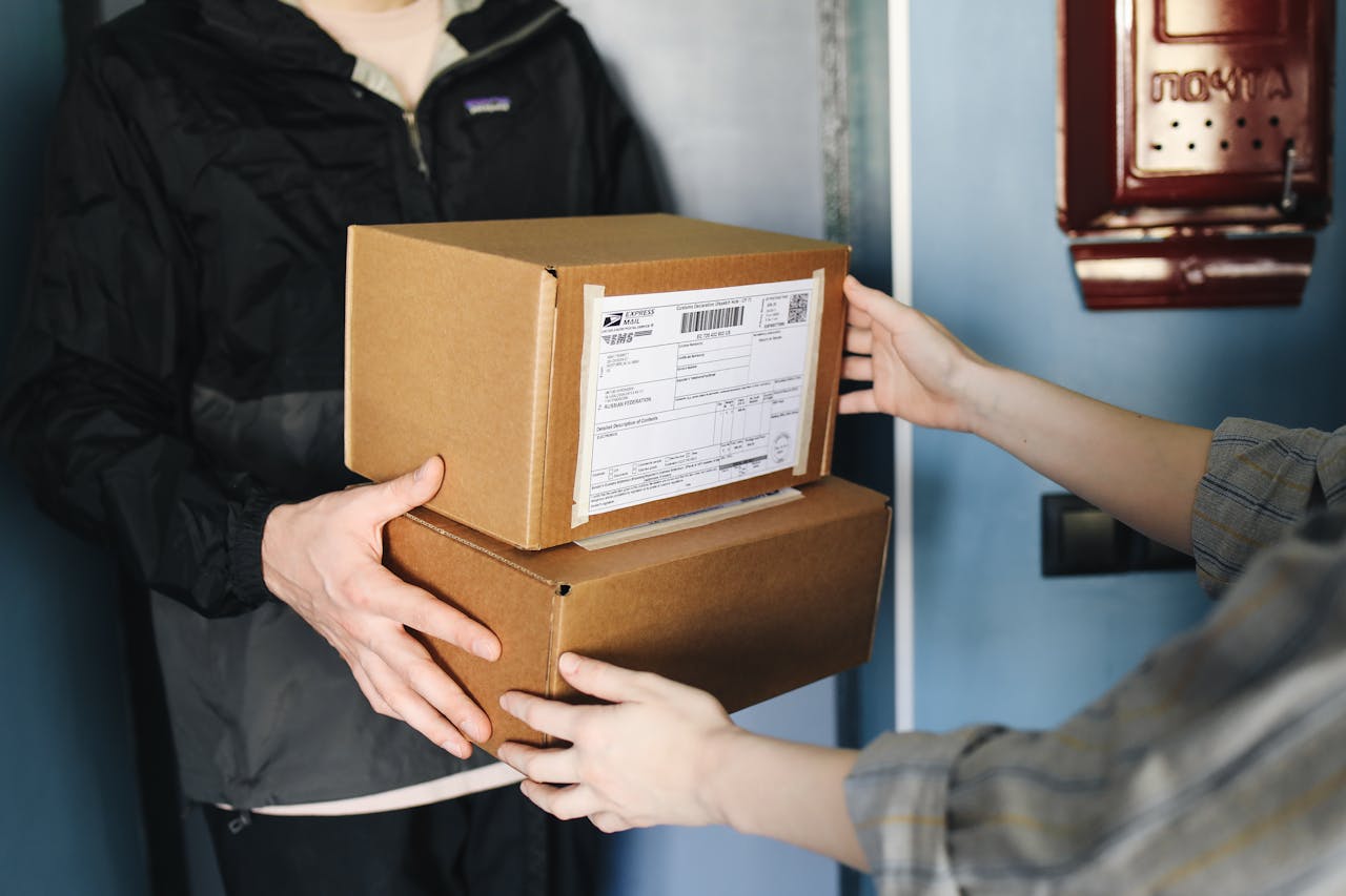 journey Close-up of hands exchanging cardboard boxes indoors, symbolizing delivery service.