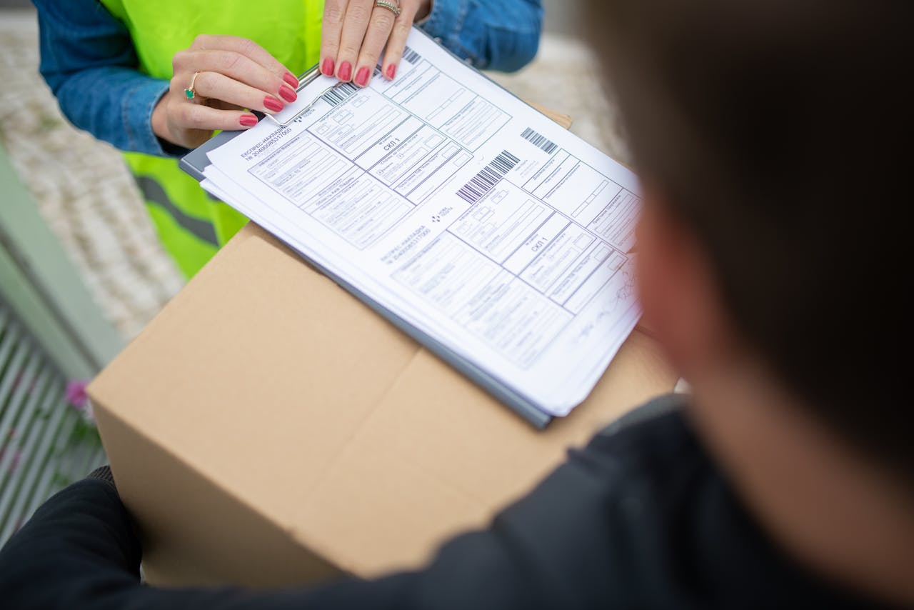 services-02 Courier hands over a package for delivery with signing of receipt documents.